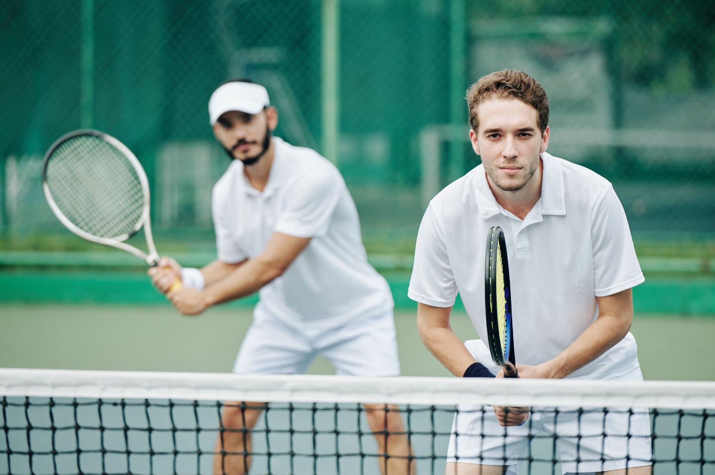 Two adult players at the net